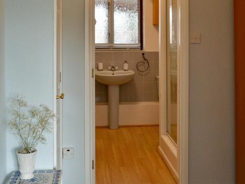 a bathroom with a sink and a toilet and a mirror at The Mount in Boxford