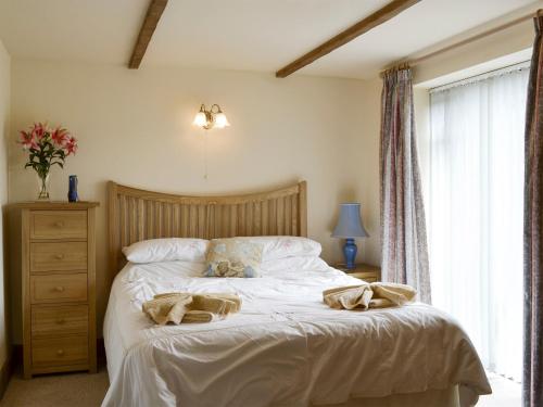 a bedroom with a bed with two towels on it at Henwood in East Meon