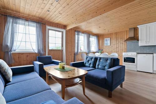 a living room with blue couches and a table at Sørreisa Fiske og Feriesenter 