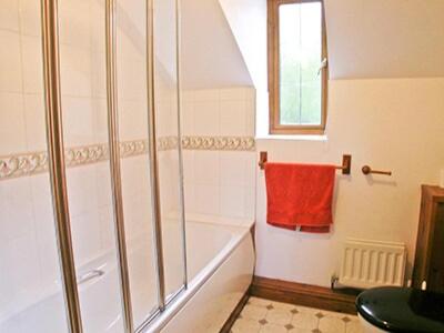 y baño con ducha y toalla roja. en Denhill Cottage en Chipstable