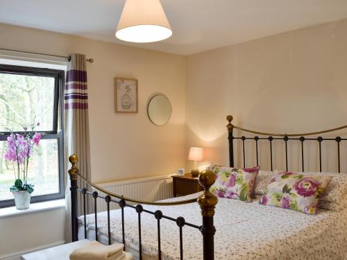 a bedroom with a bed and a window at Park View Cottage in Old Glossop