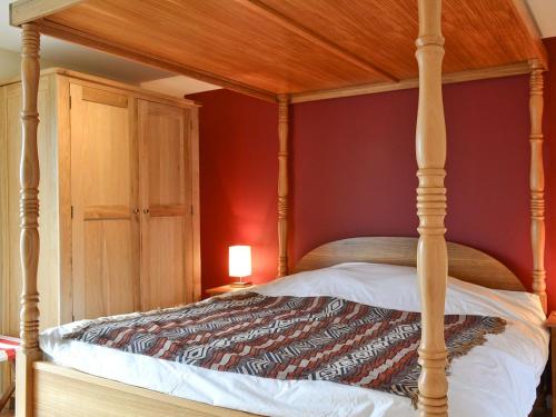 a bed with a wooden canopy in a room at Hygge in Eabost