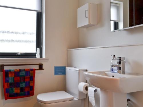 a bathroom with a sink and a toilet and a window at Hygge in Eabost