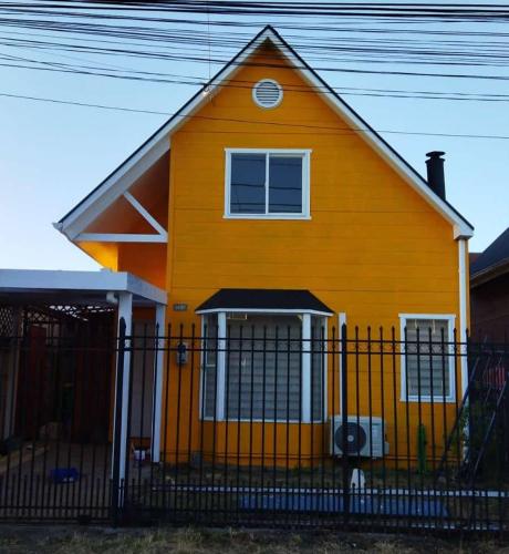 una casa amarilla con una valla delante de ella en Casa Temuco en Cajón