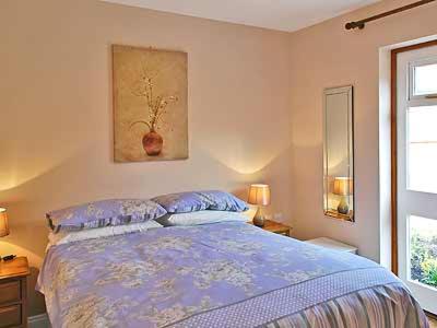 Chestnut Cottage-27565 في Botesdale: غرفة نوم مع سرير مع لحاف أزرق