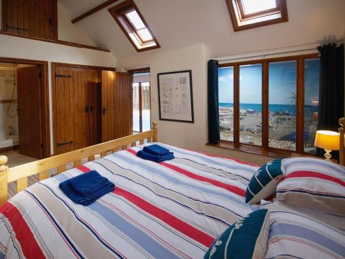 a bedroom with a large bed with blue towels on it at Coombehayes Barn in Uplyme