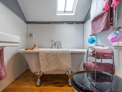 y baño con bañera y mesa de cristal. en Old Brewery Coach House-uk3003, en Haltwhistle