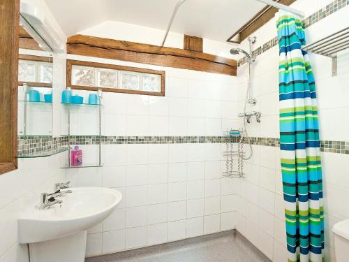 W łazience znajduje się umywalka i prysznic. w obiekcie Llofft Stabal w mieście Llanerfyl