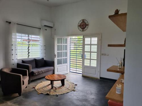 a living room with a couch and a table at Résidence Le Verger, 2ch, Kribi in Kribi