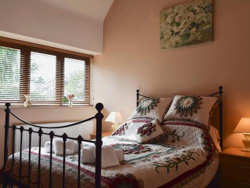 ein Schlafzimmer mit einem Bett und zwei Fenstern in der Unterkunft Alfies Barn in Ambrosden