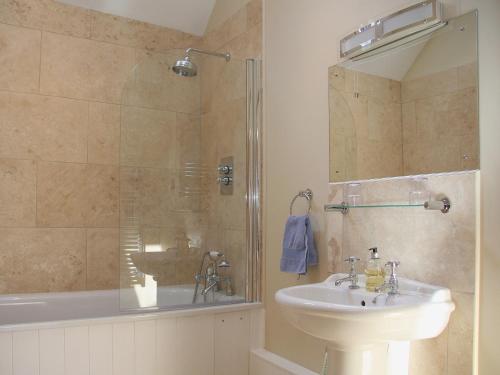 een badkamer met een wastafel en een douche bij Barn Owl Cottage in Sudbourne