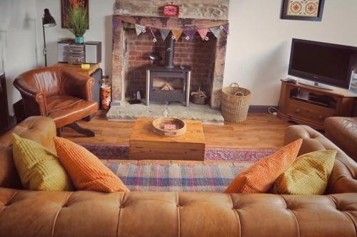 sala de estar con sofá y chimenea en Woodworth Cottage, en Barnoldswick