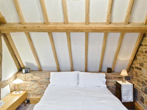 a bedroom with a white bed in a attic at Acorn Cottage in Croft