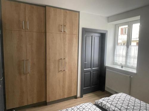 een slaapkamer met houten kasten, een bed en een raam bij Apartment Viktoria in Horn