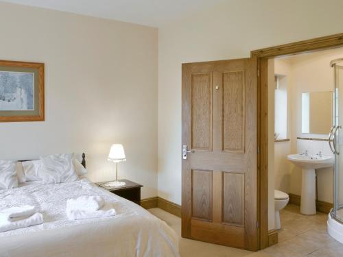 a bedroom with a bed and a sink and a toilet at Alby Bungalow in Wetheral