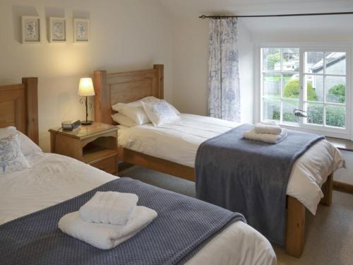 a hotel room with two beds and a window at Daisy Cottage in Thornton Dale