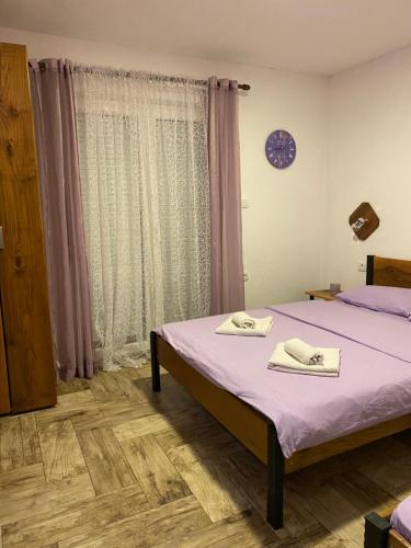 a bedroom with two beds and a clock on the wall at Apartments Shine in Kola&scaron;in