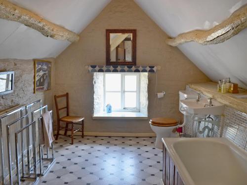 a bathroom with a sink toilet and a window at Trowley Farmhouse in Llanbedr