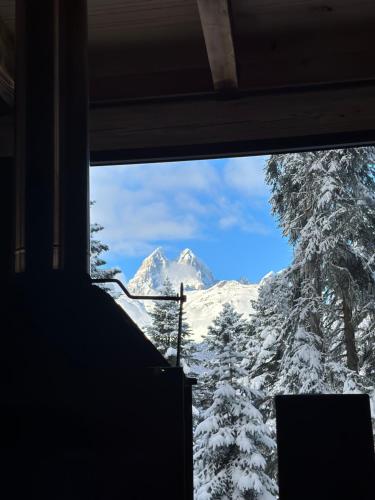 a view of a snow covered mountain through a window at Hut In Hatsvali in Mestia