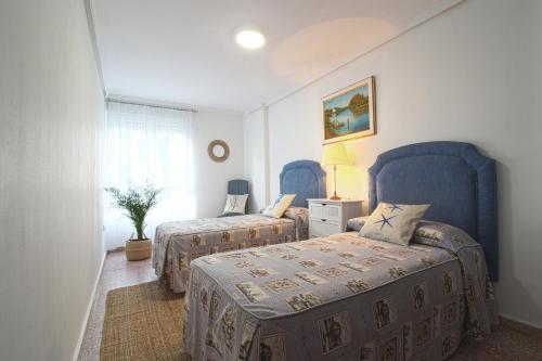 蘇安塞斯的住宿－La Luz de La Concha，一间卧室配有两张带蓝色椅子的床
