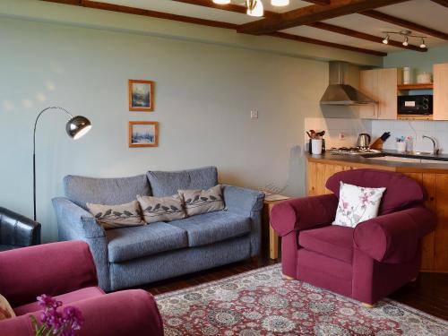 a living room with a couch and two chairs at Rose Cottage II in Scalby
