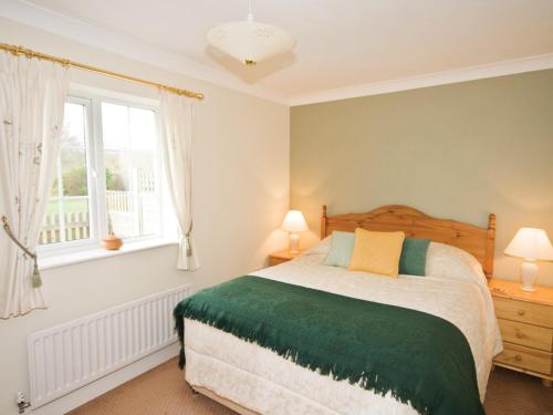 a bedroom with a bed and two windows at Mallard Cottage - E3751 in Leverton