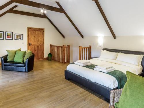 Hall Farm Cottage في Byers Green: غرفة نوم بسرير كبير وكرسي
