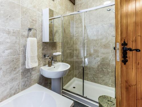 a bathroom with a shower and a sink and a toilet at Hall Farm Cottage in Byers Green