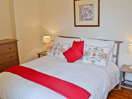 ミドルトン・イン・ティーズデールにあるThe School House - 28445のベッドルーム1室(赤と白の枕が備わるベッド1台付)