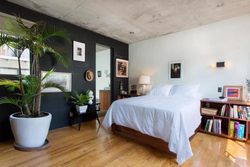 a bedroom with a white bed and a potted plant at Unique 2bedroom PH in Mexico City