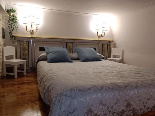um quarto com uma cama grande e 2 almofadas azuis em Refuge in Madrid em Madri