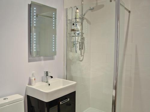 a white bathroom with a sink and a shower at Rockview in Cellardyke