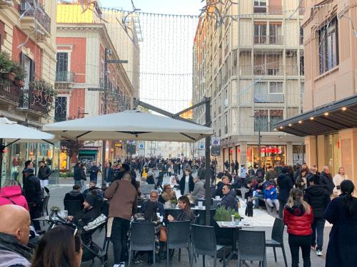 una multitud de personas sentadas en mesas en una calle en Bellissimo Loft MonStra Bari vecchia, en Bari