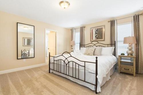 1 dormitorio con 1 cama grande y espejo en Eternal Summer at Solterra Resort villa, en Davenport