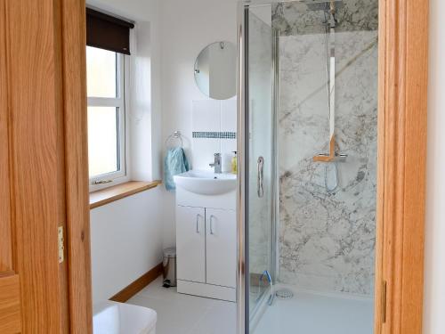 y baño con ducha y lavamanos. en Carron House en Lochcarron