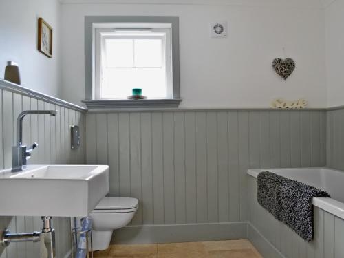 ein Bad mit einem WC, einem Waschbecken und einem Fenster in der Unterkunft Geordies Byre in Mill of Fortune