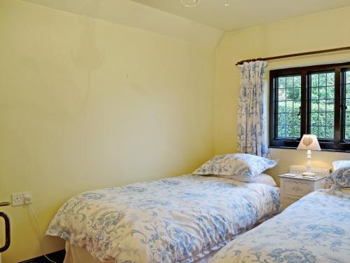 CatfieldにあるViolet Cottageのベッドルーム1室(ベッド2台、窓付)