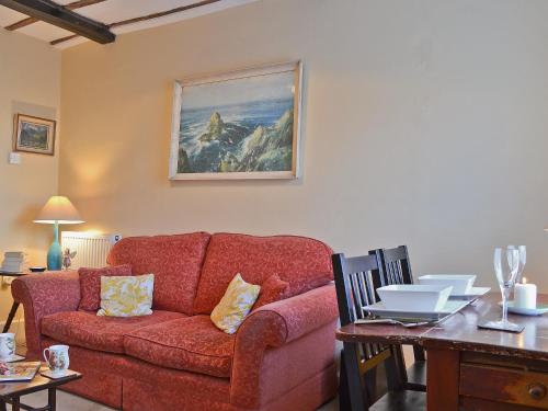 uma sala de estar com um sofá vermelho e uma mesa em Church Lane em Llanidloes