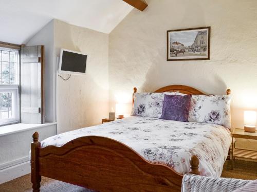 a bedroom with a bed and a tv on the wall at Bryn Euryn Cottage - 28135 in Llandrillo-yn-Rhôs
