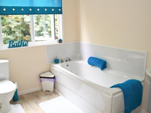 a white bath tub in a bathroom with a toilet at Bryn Euryn Cottage - 28135 in Llandrillo-yn-Rhôs