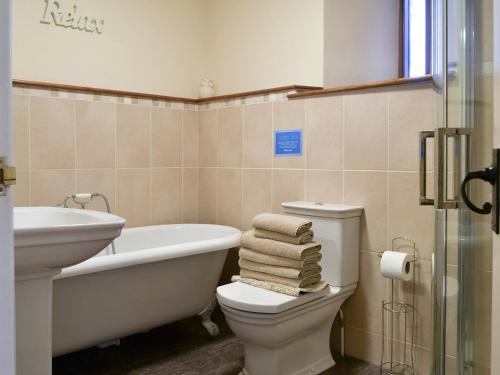 een badkamer met een bad, een toilet en een wastafel bij Barn Owl - 27820 in Westleigh