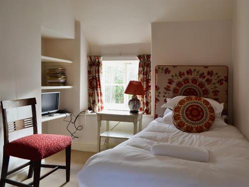 a bedroom with a bed and a chair and a desk at Mill House in Rievaulx