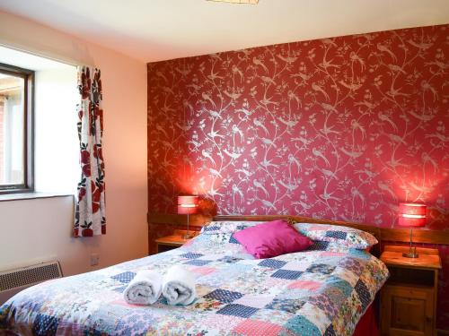a bedroom with a bed with a purple wall at Cherry - 28556 in Brighstone