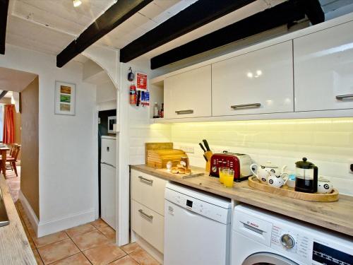 a kitchen with white cabinets and a counter top at Pilgrims Cottage in Brixham