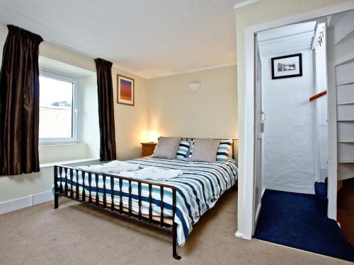 a bedroom with a bed and a window at Pilgrims Cottage in Brixham
