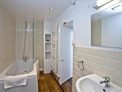 Baño blanco con bañera y lavamanos en Pilgrims Cottage, en Brixham