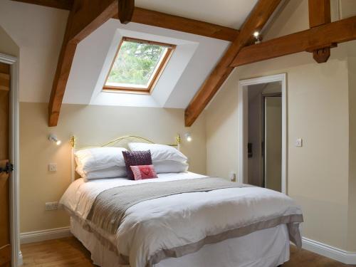 1 dormitorio con 1 cama grande y tragaluz en Holly Cottage, en Long Houghton