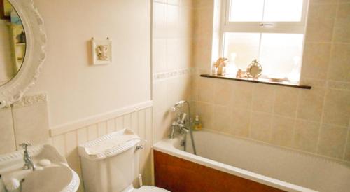 a bathroom with a sink and a toilet and a bath tub at The Well Meadow B&B in Nenagh