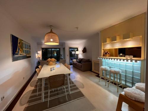 a living room with a table and a kitchen at Foz Velha House in Porto