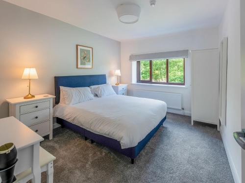 a bedroom with a blue bed and a window at The Farmhouse in High Catton